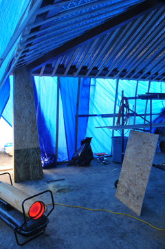 Mark Becker continues on the detailing of the activity shelter, which he has tarped and heated to make the work easier.  The blue glow of the tarps mixed with the orange from the portable heater gave the space an eerie glow.