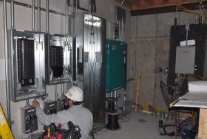 favreau-wiring-in-mechanical-room-2-23-11 The crew from Favreau Electric wiring the complicated service panels. The panel servicing the solar panels has yet to be installed.